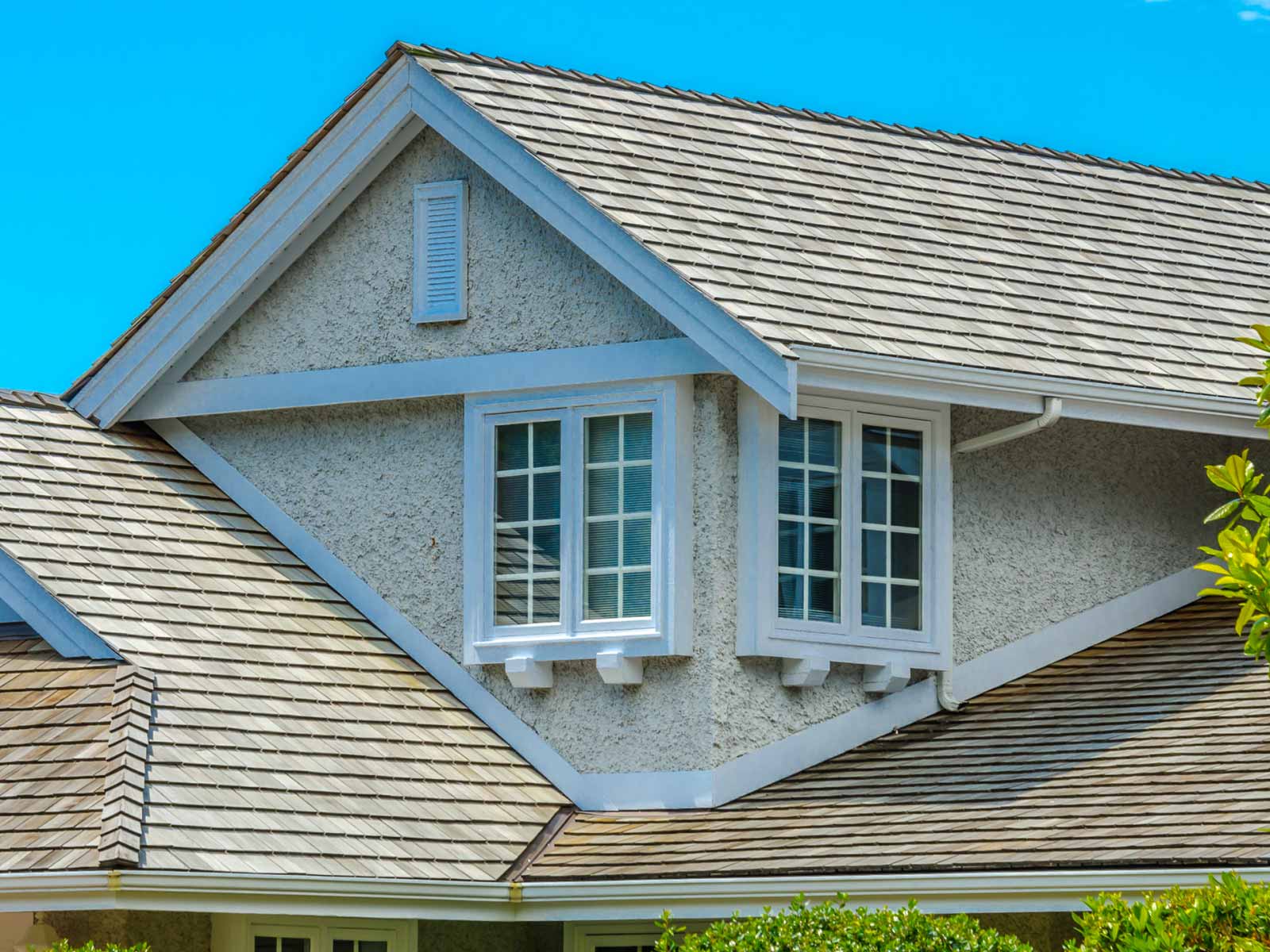 Angled view of house roof and window.